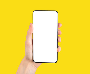 Poster - Hand holding phone mockup in vertical position on yellow background. Smartphone template with blank screen for mobile application, social networking site ad.