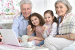 © aletia2011 - Grandfather and grandmother with children are sitting with a laptop