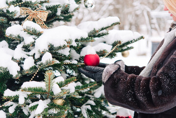 Canvas Print - branches of the Christmas tree with New Year's toys are covered with snow. Festive New Year and Christmas background. Live spruce. Bright winter landscape with snow-covered pines.