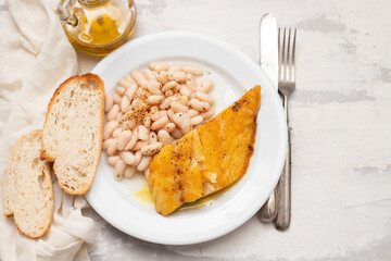 Poster - Fried cod fish with white beans on the plate.