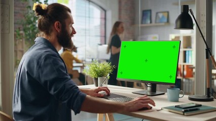 Fototapete - Creative Project Manager Working on Desktop Computer with Green Screen Mock Up Display. Bohemian Style Inspired Handsome Marketing Specialist Planning a Project, Browsing Internet and Writing Emails.