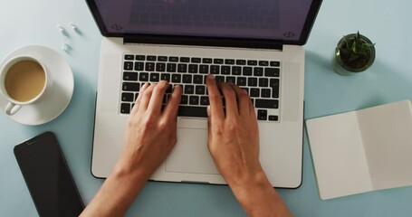 Wall Mural - hands using laptop with smartphone, notepad, plant and coffee on blue desk