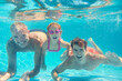 © Monkey Business - Portrait Of Multi-Generation Family On Summer Holiday Swimming Underwater In Pool