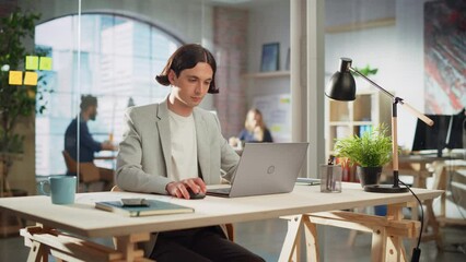 Poster - Creative Project Manager Sitting at a Desk, Working on a Laptop Computer in an Office. Handsome Marketing Specialist in a Casual Jacket Planning a Project, Browsing Internet and Writing Emails.