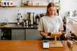 © Drobot Dean - Blonde white barista woman working with tablet computer in cafe