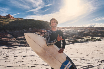 Wall Mural - Surf beach man looking directly at the camera while posing with surf board near the ocean