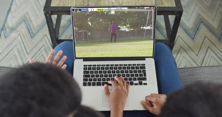 Poster - Video of two african american people sitting on the couch and watching football match on laptop