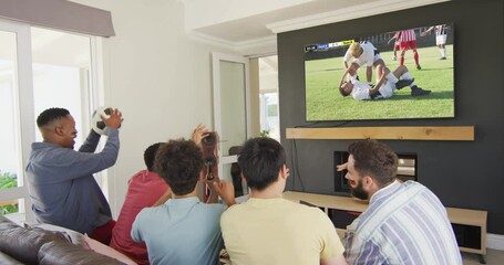 Canvas Print - Video of diverse group of friends sitting on the couch and watching football match