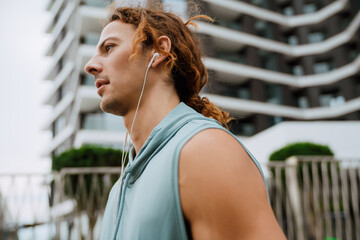 Wall Mural - Profile portrait of young handsome long-haired man in headphones