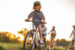 © pikselstock - Happy family cycling together in the countryside