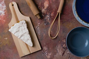 Canvas Print - Slice of chocolate cake with meringues on the surface was placed on a wooden cutting board