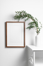 Portrait Frame Mockup For Artwork On White Wall With Natural Eucalyptus Twigs.