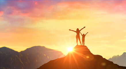 Wall Mural - Mother and daughter meet dawn at peak in mountains. Woman on mountain peak with open arms welcoming new day with sunrise. Success, Leadership, Winner on top.