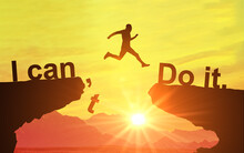 Silhouette Of Man Jumping And Change I Can't Do It To I Can Do It Text On Mountain, Sky And Sun Light Background. Motivation, Business, Success, Achievement And Idea Concept.
