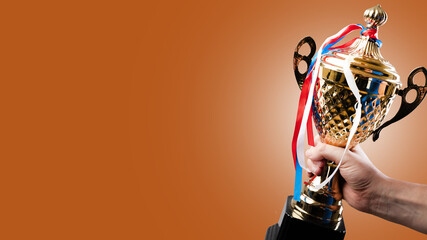 Award golden cup of the winner and medals on multi-colored ribbons on a beige background. Awards for achievements in sports, music, science. There is free space to insert.