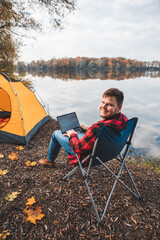 Poster - man sitting in chair near autumn lake