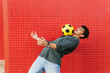 © ADDICTIVE STOCK - Hispanic male doing trick with football ball