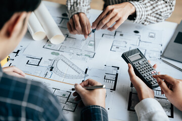 Close up of hands working brainstorming and measuring for cost estimating on paperworks and floor plan drawings about design architectural and engineering for houses and buildings.