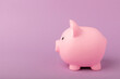 © Avocado_studio - Piggy bank on a lilac texture background. Close-up. Space for copy. Flat lay. Savings and accumulation concept.