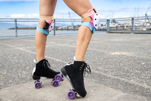 Close Up View Of Woman Legs Wearing Roller Skates With Wheels And Knee Pads For Safety And Protection While Having Fun At The Park. 