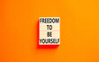 Freedom to be yourself symbol. Concept words Freedom to be yourself on wooden blocks on a beautiful orange table orange background. Business, psychological freedom to be yourself concept.