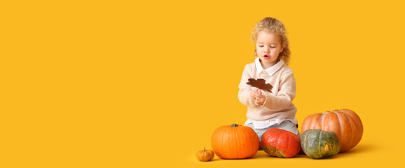 Sticker - Cute little girl in warm sweater, with autumn leaf and pumpkins on yellow background with space for text