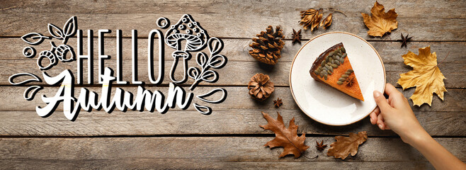Female hand, plate with piece of delicious pumpkin pie and dry leaves on wooden background. Hello, autumn
