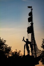 Vertical Shot Of A Statue Of A Captain On A Sailing Boat During A Beautiful Sunset