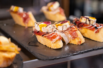 Typical snack of Basque Country and Navarre, pinchos or pinxtos served in bar, small slices of bread upon which ingredient or mixture of ingredients is placed, San Sebastian, Spain