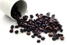 Coffee Beans Outpour A Cup On A White Background