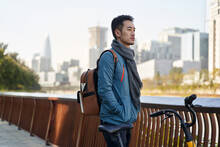 Young Asian Adult Man With Backpack And Bicycle Looking At View Thinking