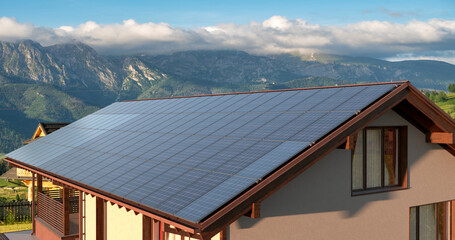 Wall Mural - photovoltaic panels on the roof of a modern house in the mountains