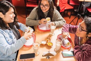 Group of young friends eating in a mexican restaurant