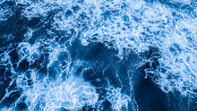 Top View Aerial Photography White Sea Foam Against The Background Of The Blue Sea Or Ocean. Background, Screensaver