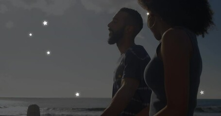 Sticker - Animation of stars over diverse couple at beach