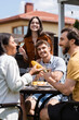 © LIGHTFIELD STUDIOS - Smiling interracial friends spending time during bbq party with wine outdoors