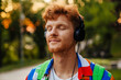 © Drobot Dean - Young handsome peaceful redhead man in headphones with closed eyes