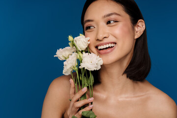 Wall Mural - Portrait of young beautiful happy asian woman with white flowers