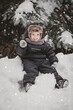 © Юлия Клюева - Portrait of a beautiful little European boy in winter under a snow-covered fir tree in the park. The concept of childhood and lifestyle.