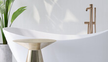 Realistic 3D Render A Blank Empty Golden Podium For Products Mock Up In Modern Luxury Bathroom With White Ceramic Bathtub And Golden Faucets Set In Background. Tropical Green Leafs Plant, Copy Space.