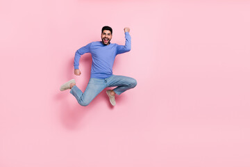 Wall Mural - Full length photo of lucky funky guy dressed blue pullover jumping high empty space isolated pink color background
