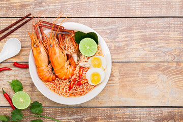 Poster - Tom Yum Goong Instant Noodle Ramen - Asian Style Thai and Chinese are spicy. Placed on a wooden table, seafood shrimp, lime, red chili, garlic, galangal, lemongrass, kaffir lime stand original,