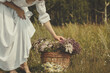 © junky_jess - Faceless barefoot woman in vintage white dress bend over to the basket of herbs on the edge of the forest in summer, selective focus.