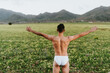 © ADDICTIVE STOCK - Anonymous shirtless guy admiring nature while standing in field with outstretched arms