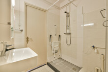 Interior of disable shower cabin with faucet and tiled walls