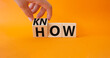 Know how symbol. Businessman hand turnes wooden cubes and changes word How to Know. Beautiful orange background. Business and Know how concept. Copy space.
