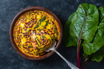 Wall Mural - Ceramic bowl with vegetable frittata. Frittata with eggs, green beet leaves, onion, pepper, spices and cheese