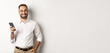 © Mix and Match Studio - Handsome manager using smartphone and smiling pleased, sending text message, standing over white background