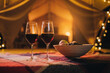 Two glass of red wine and plate with fruits standing on background of cozy glamping tent on autumn evening. Luxury camping tent for outdoor holiday and vacation. Lifestyle concept