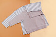 © Дарья Воронцова - Baby sneakers,t shirt,jumper.Set of children's clothes and accessories for spring, autumn or summer.Fashion kids outfit,clothing on beige brown background.Flat lay, top view, overhead